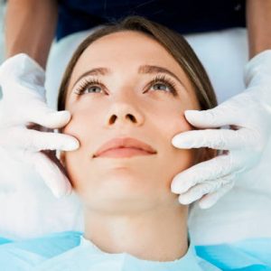 Cosmetologist preparing to doing cosmetic facial treatments for the young woman Cosmetologist preparing to doing cosmetic facial treatments for the young woman